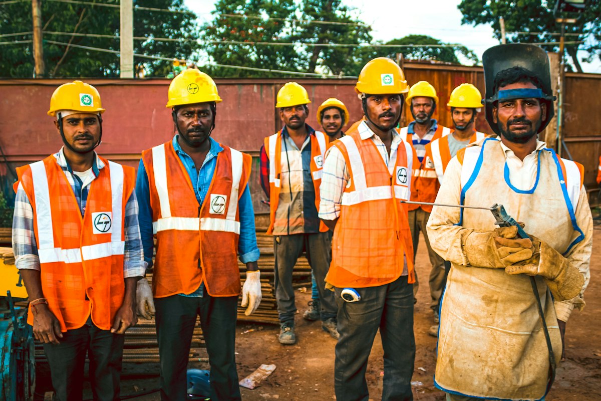Trabajadores con chaleco reflectante y casco en faena